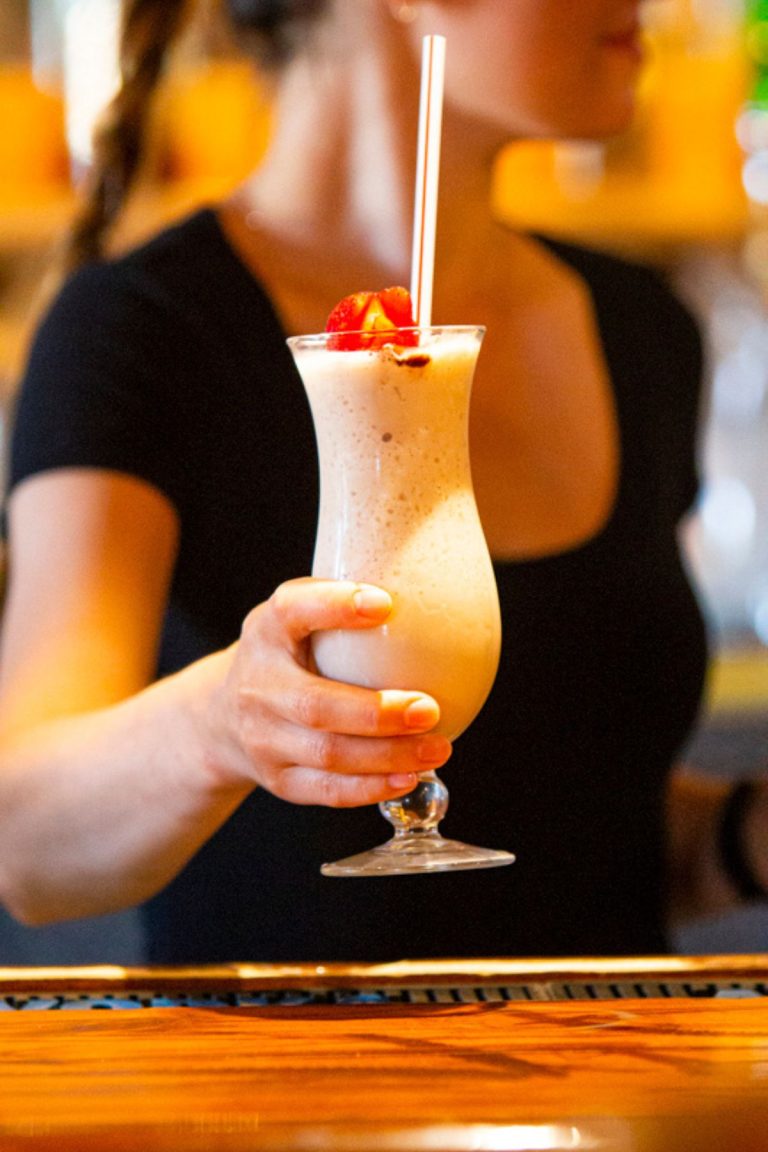 Waitress holding a tropical drink in hand photography social media services for restaurants in Florida