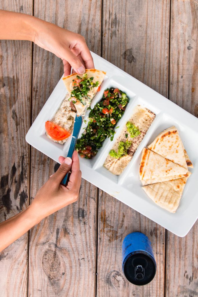 Swift Grill's Mediterranean platter served in Fort Pierce, Florida, showcasing an assortment of traditional dishes including hummus, tabbouleh, and pita bread.